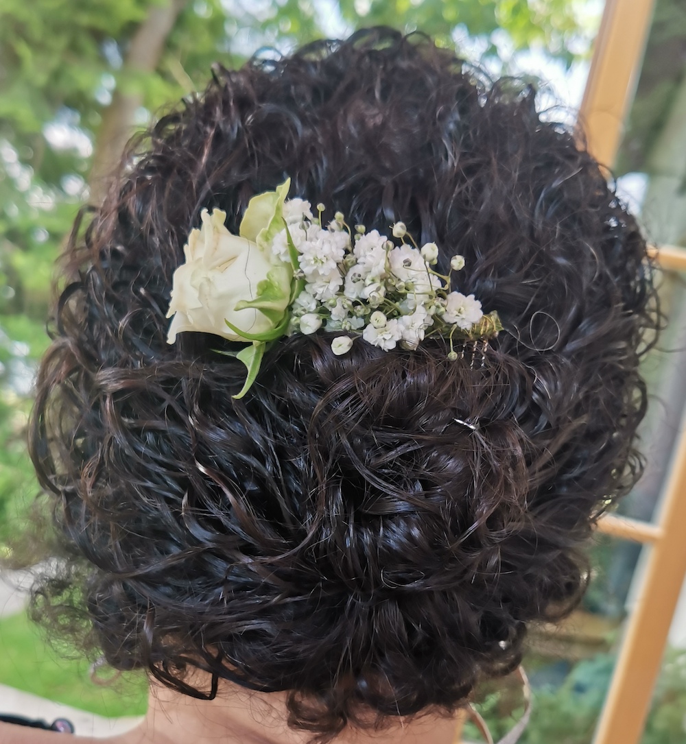 Hochsteckfrisur von Hinten, Locken, gehalten von einem blumengeschmückten Kamm